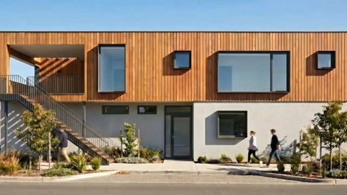 Wohngebäude mit Holzfassade, Putzsockel und Aussentreppe nach der Sanierung